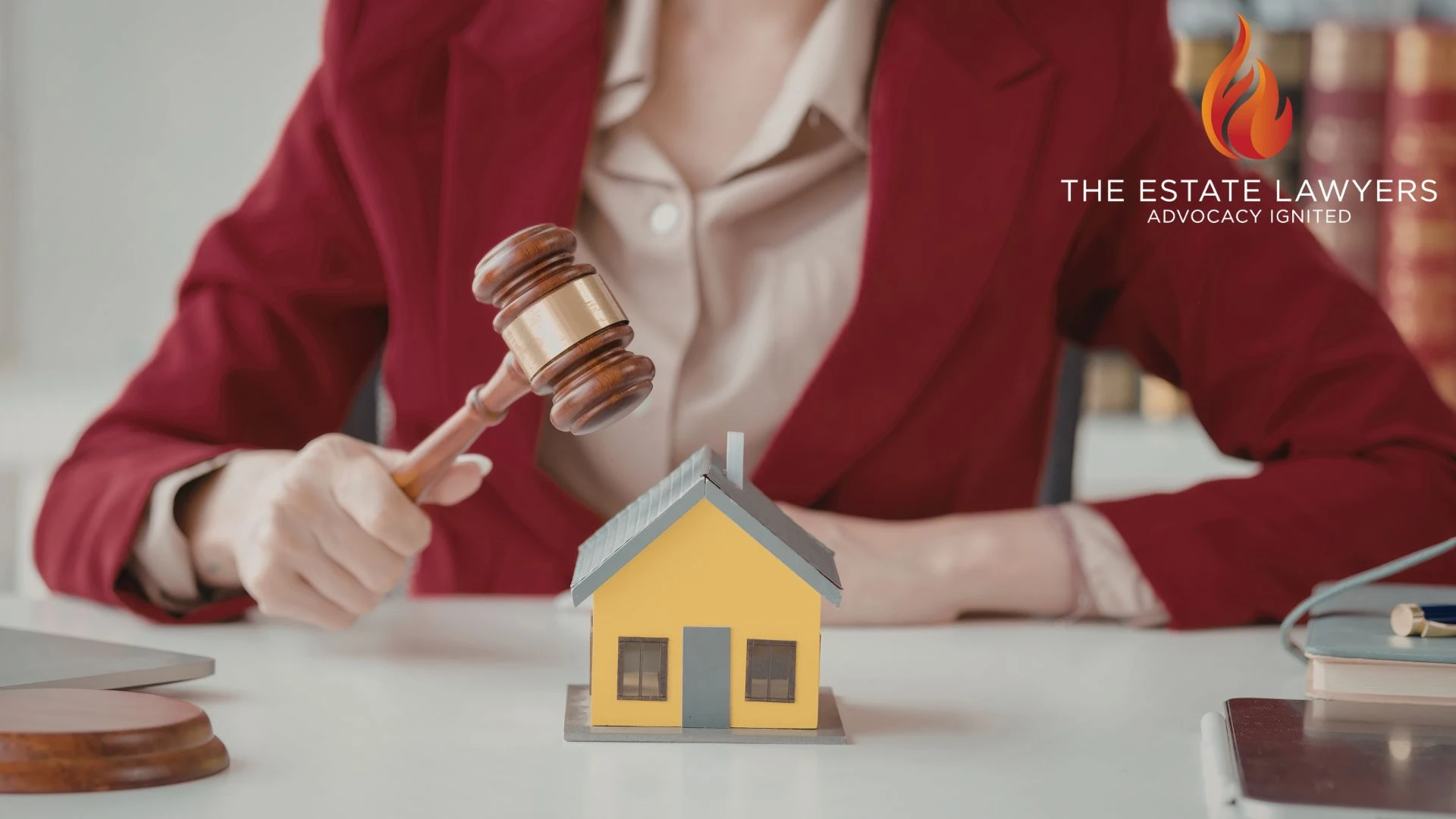 Lawyer holding gavel beside model house