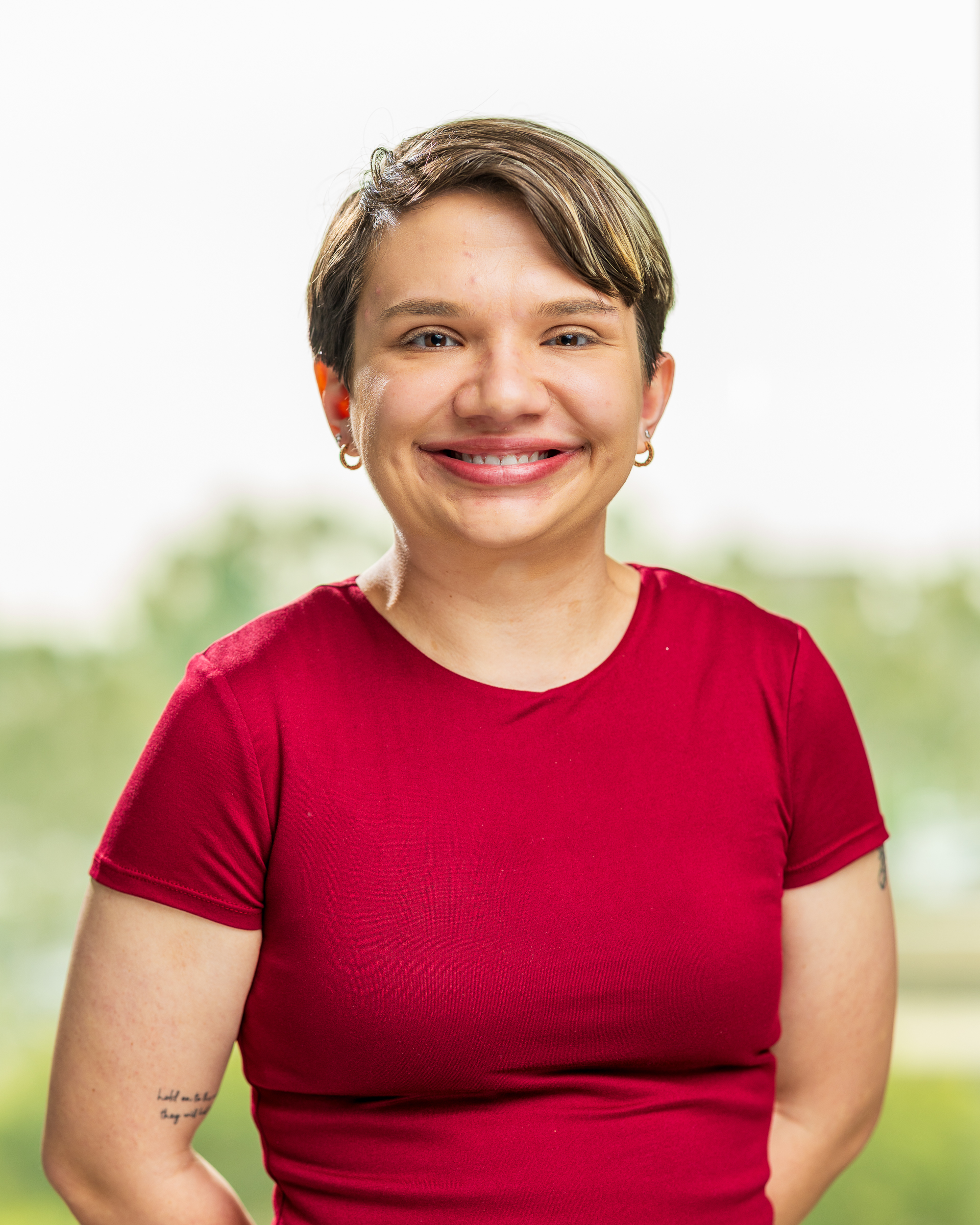 Smiling person wearing red shirt outdoors
