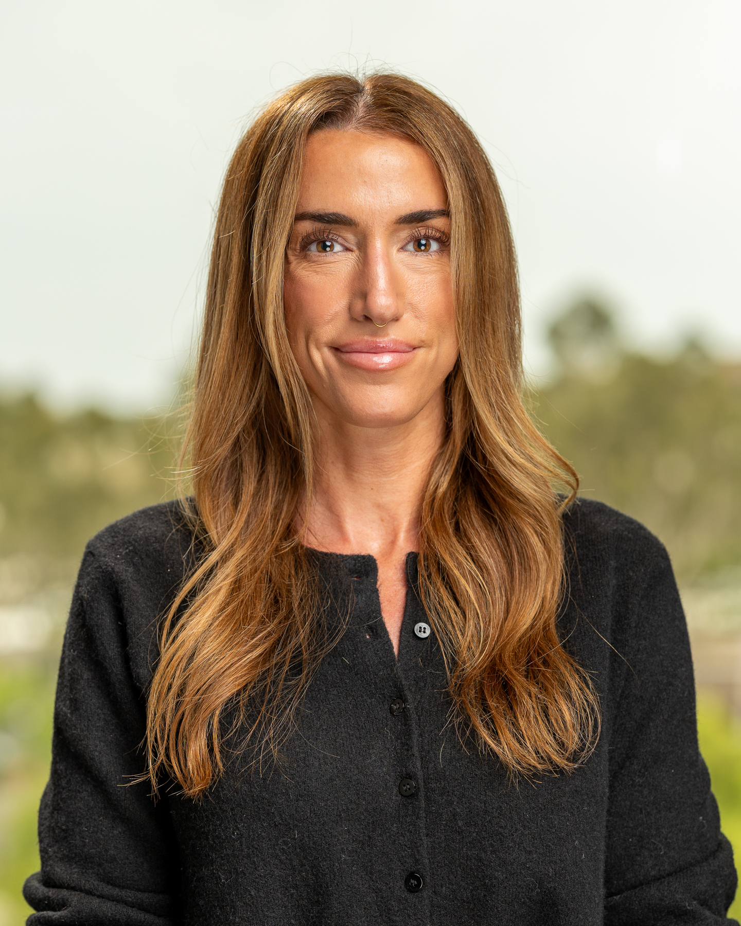 Woman with long hair smiling outdoors