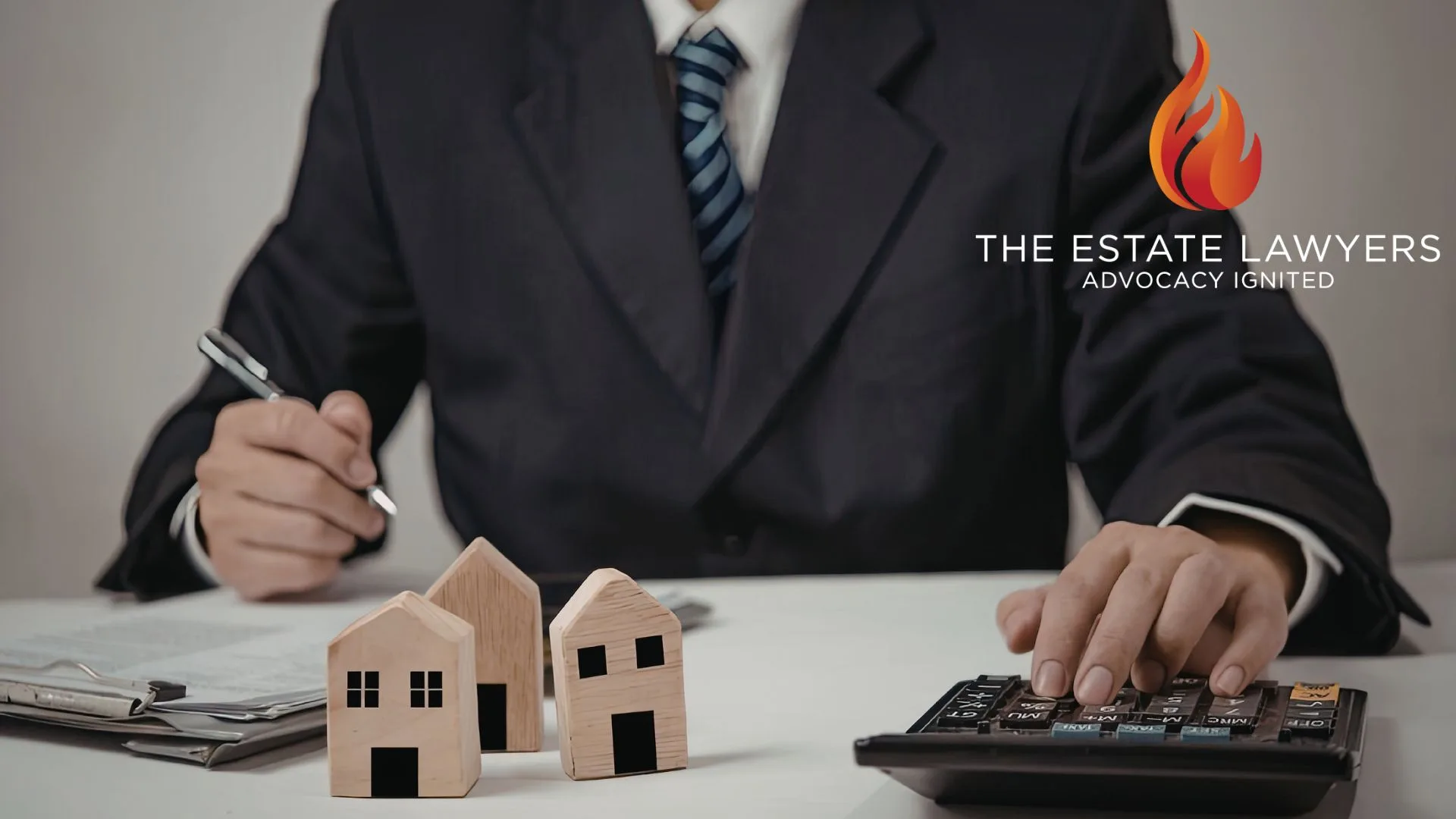 Lawyer calculating estate planning costs with house models after estate dispute