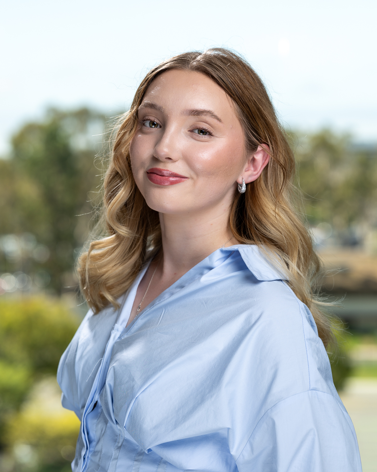 Smiling woman in blue blouse outdoors portrait