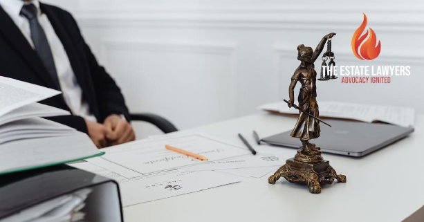 A legal professional's workspace featuring Lady Justice statue, documents, and a laptop, illustrating trust petition attorney in Fresno. Branded with the The Estate Lawyers, APC logo.